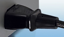 An AC power cord plug inserted into a desktop AC receptacle